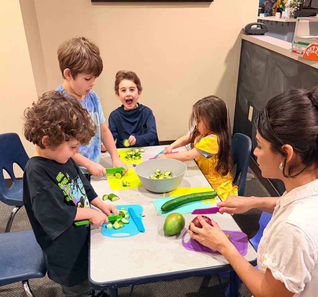 Monica Hidalgo teaching children to cut vegetables during a culinary nutrition workshop